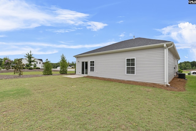 rear view of house with a patio, a yard, and central air condition unit