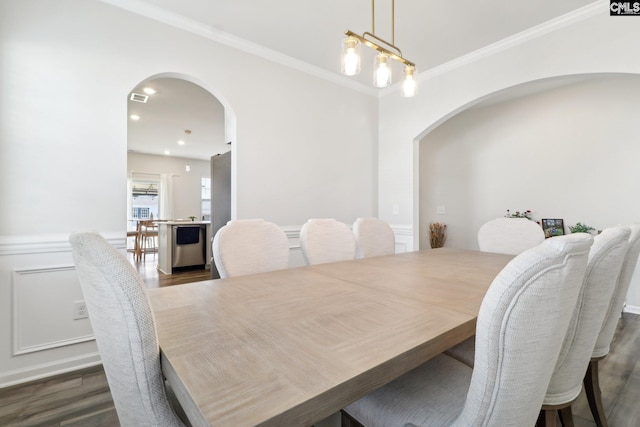 dining room featuring ornamental molding, a chandelier, and dark hardwood / wood-style flooring