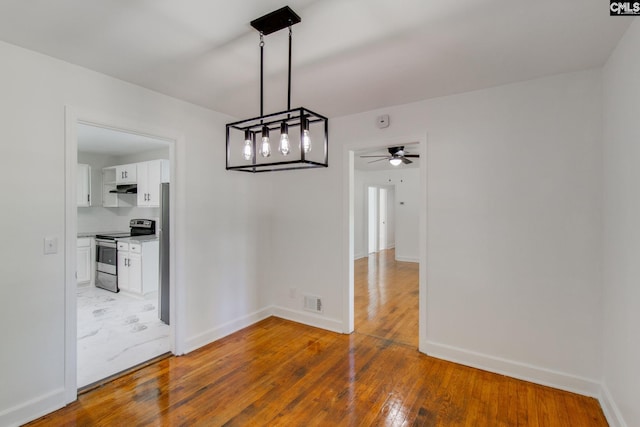 unfurnished dining area with hardwood / wood-style flooring and ceiling fan