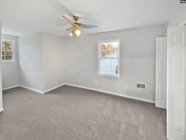 carpeted spare room with ceiling fan and a healthy amount of sunlight