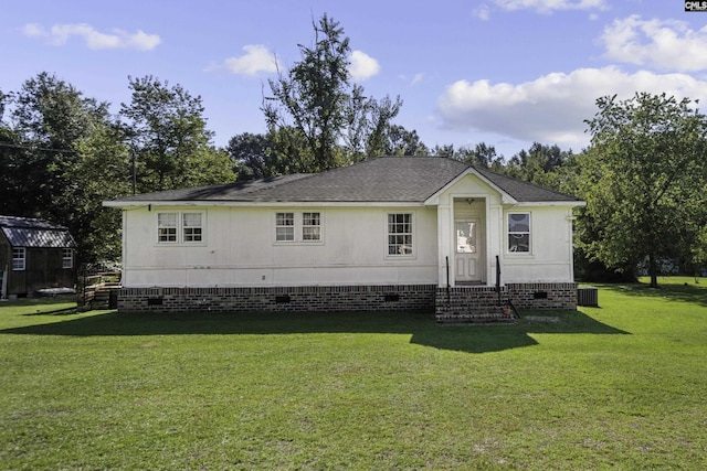 view of front of property with a front yard and central AC unit