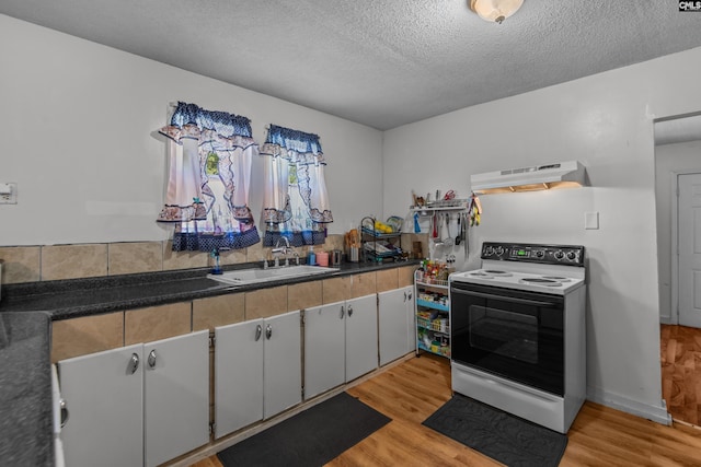 kitchen featuring sink, range with electric cooktop, light hardwood / wood-style floors, and a textured ceiling