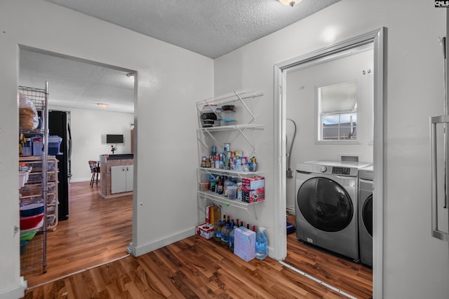 laundry area with independent washer and dryer, dark hardwood / wood-style floors, and a textured ceiling