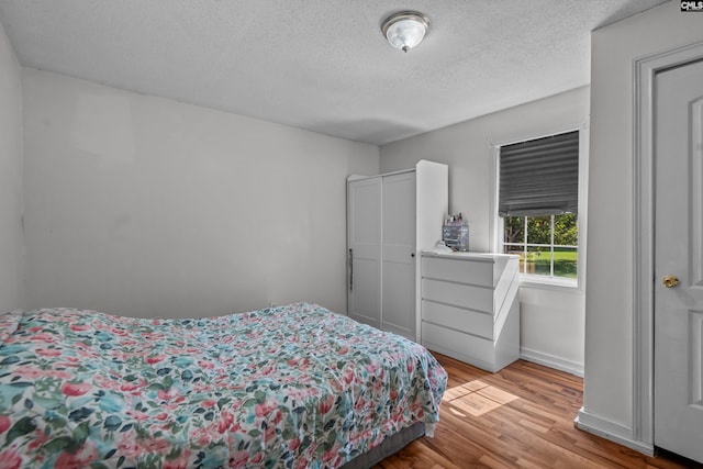 bedroom featuring a textured ceiling and light wood-type flooring