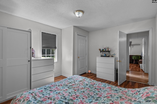 bedroom featuring dark wood-type flooring and a textured ceiling