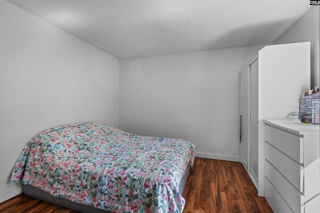 bedroom with dark hardwood / wood-style flooring