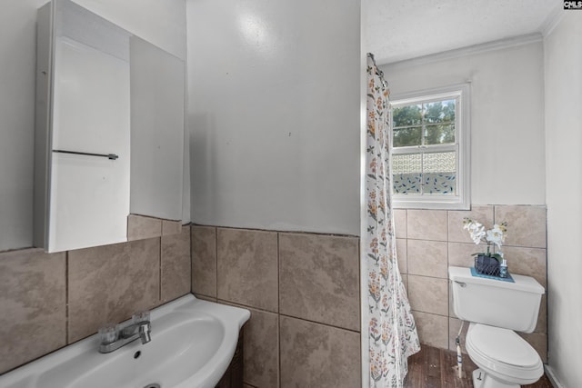 bathroom with sink, tile walls, and toilet