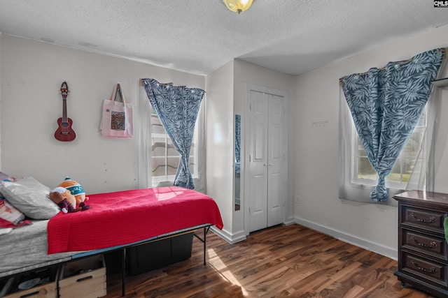 bedroom with dark hardwood / wood-style flooring, a closet, and a textured ceiling