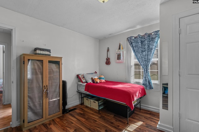 bedroom with dark wood-type flooring and a textured ceiling