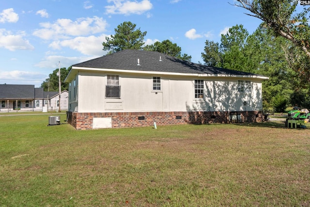 view of side of property with a yard and central AC unit