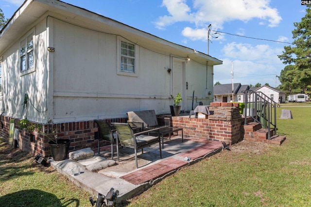 rear view of property with a patio and a lawn