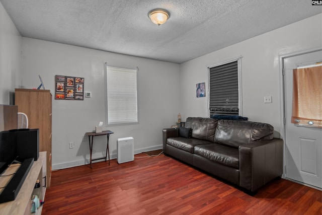 living room featuring dark hardwood / wood-style floors and a textured ceiling