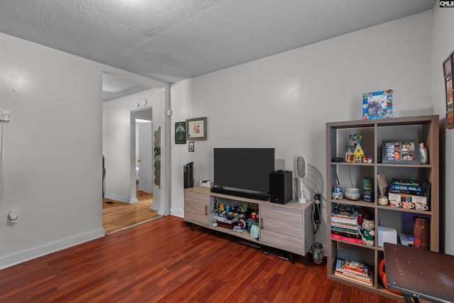 living room featuring a textured ceiling and dark hardwood / wood-style flooring