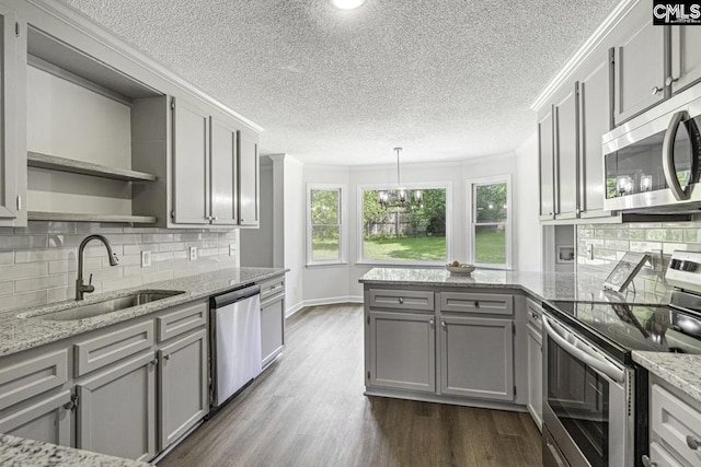 kitchen with sink, crown molding, gray cabinetry, stainless steel appliances, and dark hardwood / wood-style flooring