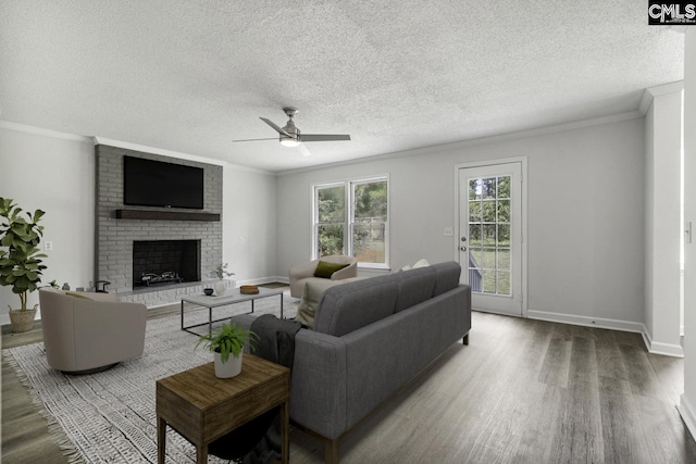 living room with ornamental molding, hardwood / wood-style floors, ceiling fan, and a fireplace