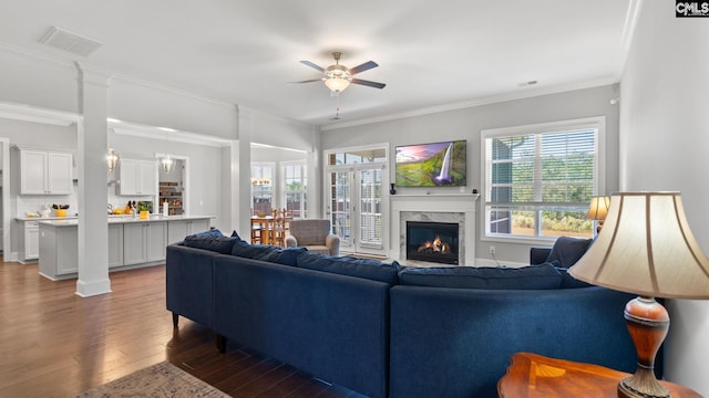 living room featuring crown molding, dark hardwood / wood-style floors, ceiling fan, and a high end fireplace