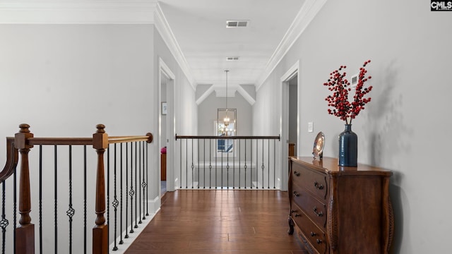 hallway featuring crown molding, dark hardwood / wood-style flooring, and an inviting chandelier