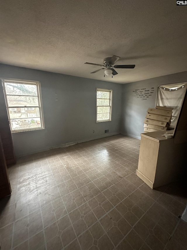 spare room featuring ceiling fan and a textured ceiling