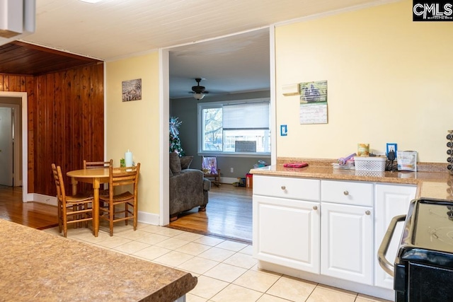 kitchen with white cabinetry, light tile patterned floors, electric range, and ceiling fan