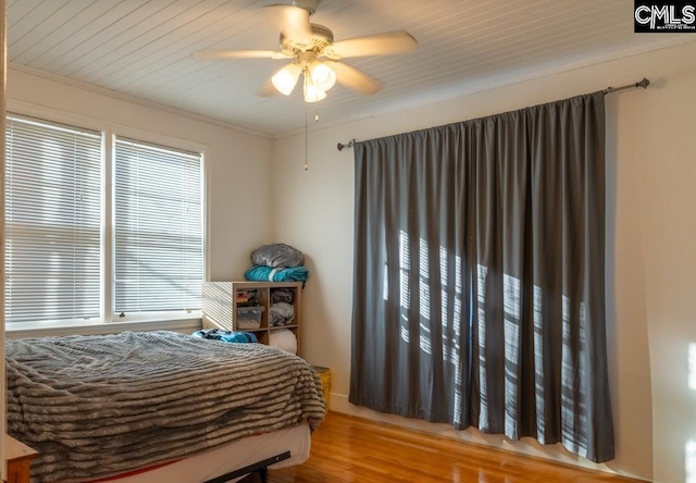 bedroom with wood-type flooring, ornamental molding, and ceiling fan