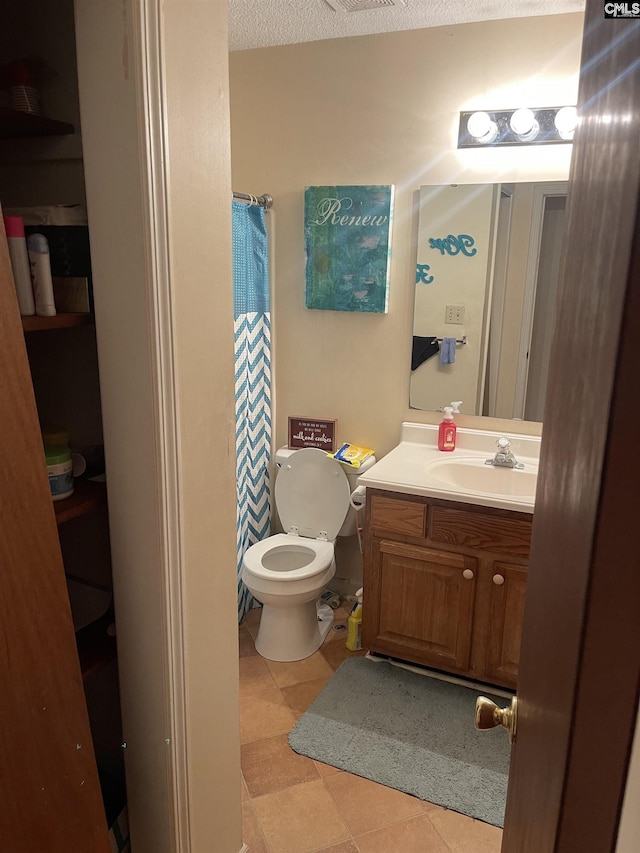 bathroom featuring vanity, tile patterned flooring, curtained shower, and toilet