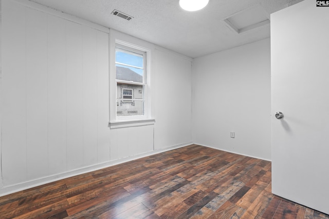 empty room featuring dark hardwood / wood-style floors and a textured ceiling