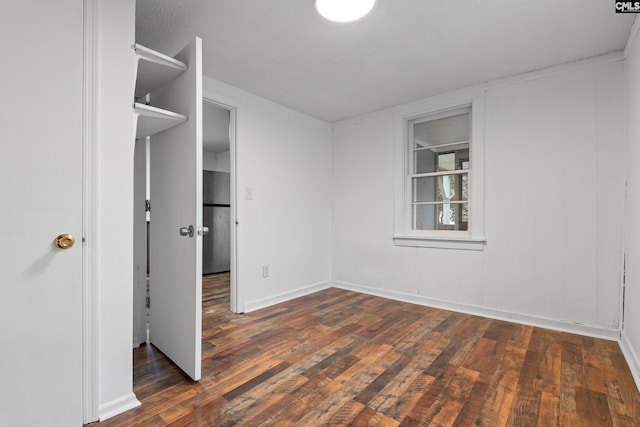 unfurnished room with dark wood-type flooring