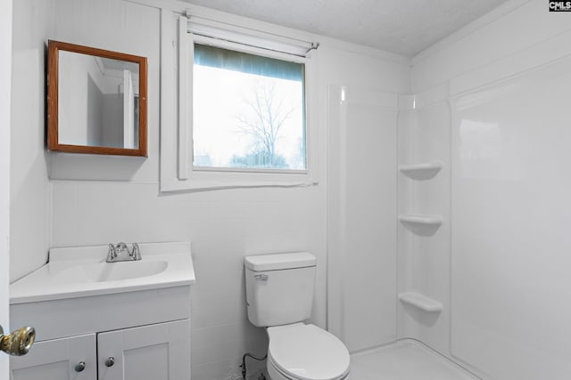 bathroom with vanity, a shower, toilet, and a textured ceiling