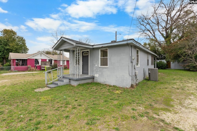 view of front of property with central AC and a front yard