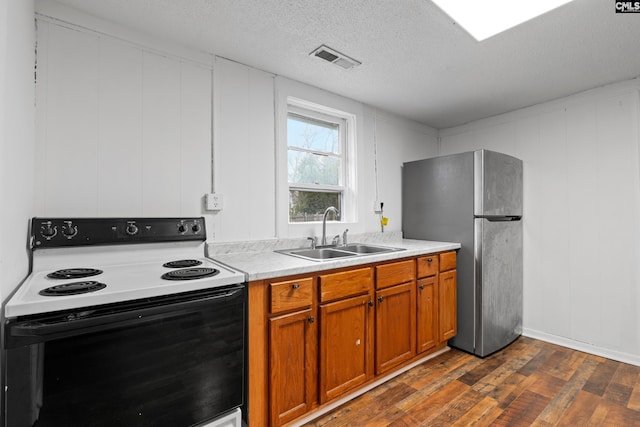 kitchen featuring sink, stainless steel fridge, electric range, dark hardwood / wood-style floors, and a textured ceiling