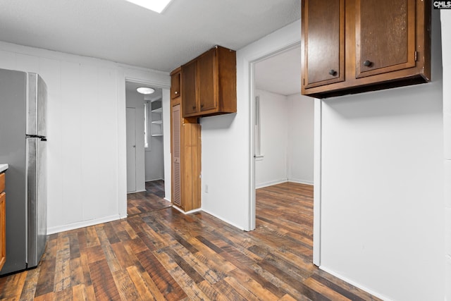 kitchen with dark hardwood / wood-style flooring and stainless steel refrigerator