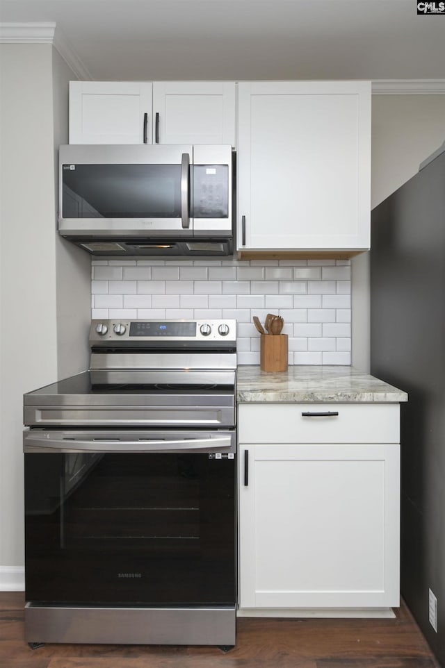 kitchen with white cabinetry, backsplash, and stainless steel appliances