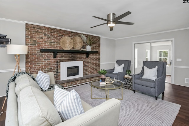 living room featuring wood-type flooring, a brick fireplace, and crown molding