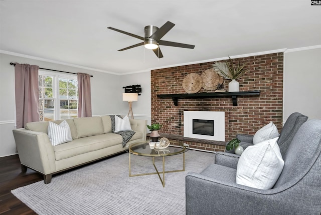 living room featuring crown molding, a fireplace, ceiling fan, and hardwood / wood-style flooring