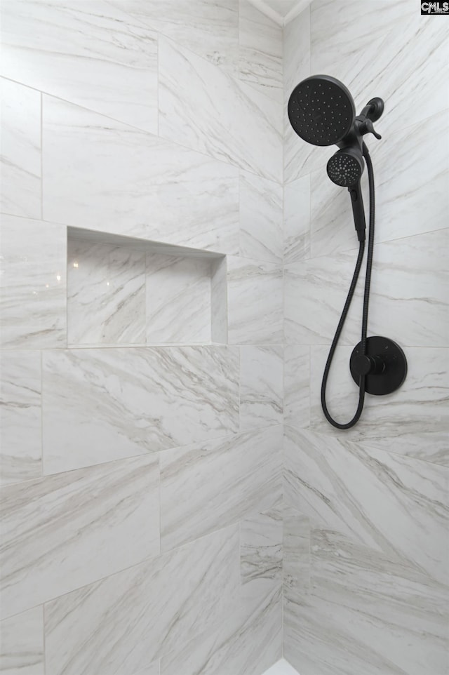 interior details featuring a tile shower