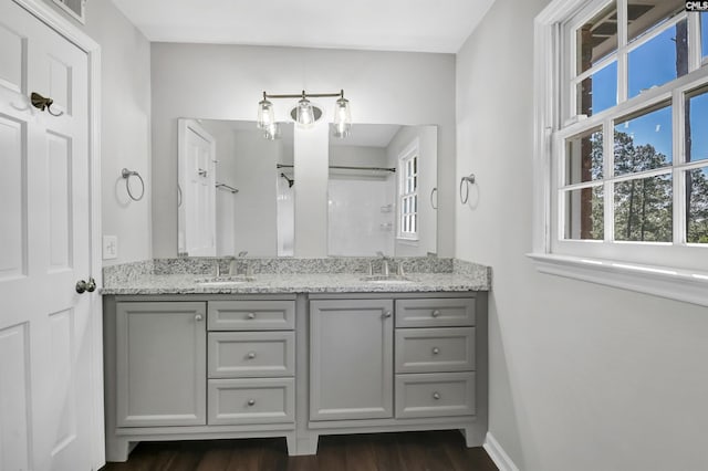 bathroom with hardwood / wood-style flooring, vanity, and a shower