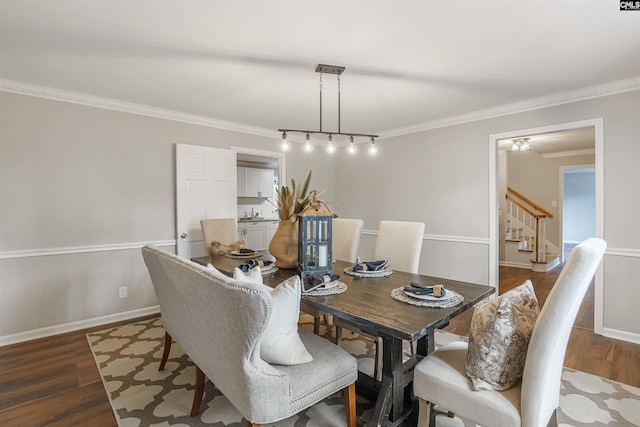 dining space with dark wood-type flooring and crown molding