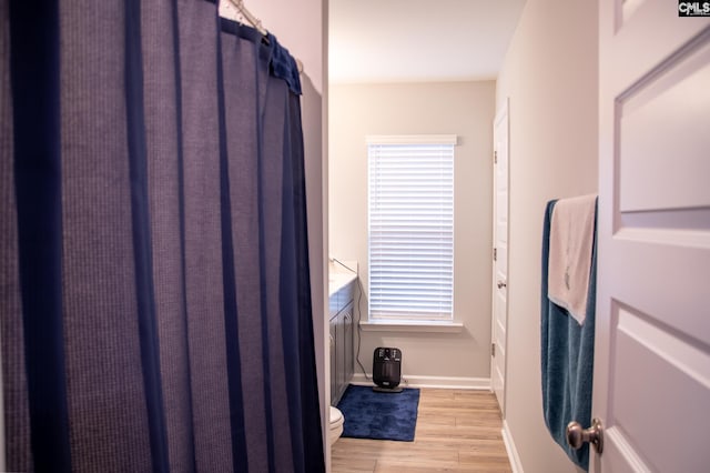 bathroom with wood-type flooring and toilet