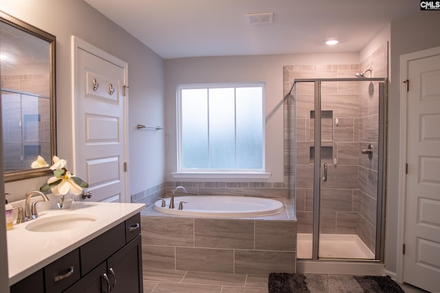 bathroom featuring vanity and separate shower and tub