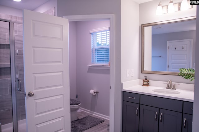 bathroom with vanity, an enclosed shower, and toilet