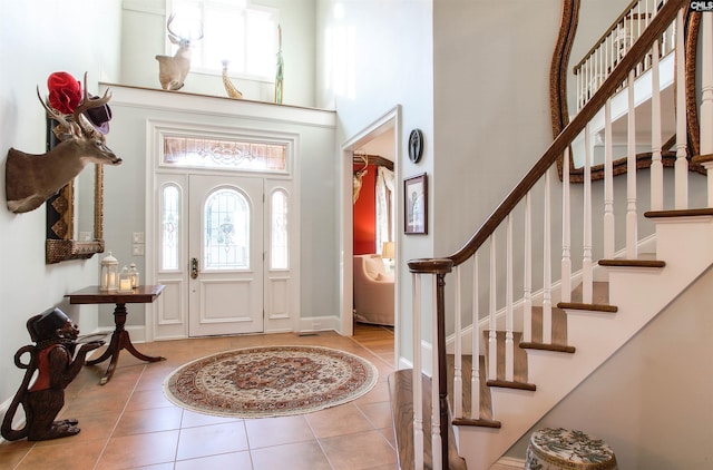 foyer featuring light tile patterned flooring and a towering ceiling