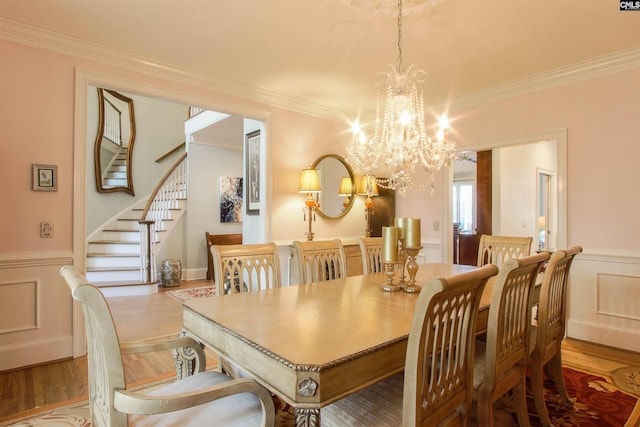 dining space featuring hardwood / wood-style floors, a notable chandelier, and ornamental molding