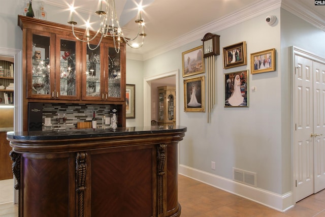 bar featuring crown molding, decorative light fixtures, a chandelier, and tasteful backsplash