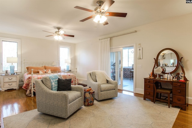 bedroom featuring ceiling fan, light hardwood / wood-style floors, and multiple windows