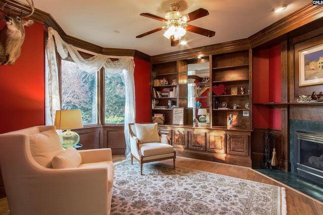 sitting room with hardwood / wood-style flooring, ceiling fan, and a fireplace