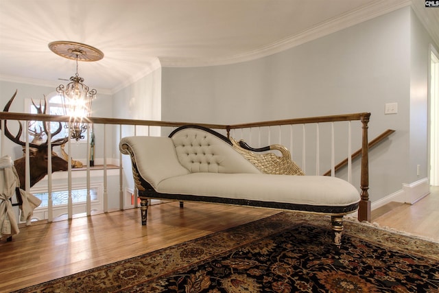 living area with hardwood / wood-style flooring, crown molding, and a notable chandelier