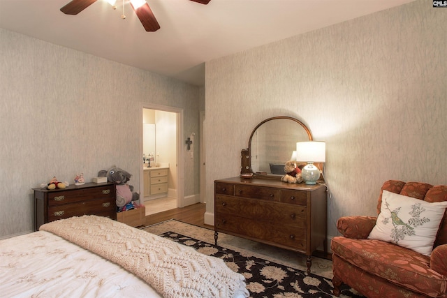 bedroom with hardwood / wood-style flooring, connected bathroom, and ceiling fan