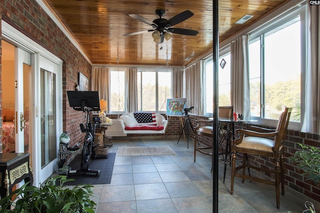 sunroom / solarium with ceiling fan, wooden ceiling, and a healthy amount of sunlight