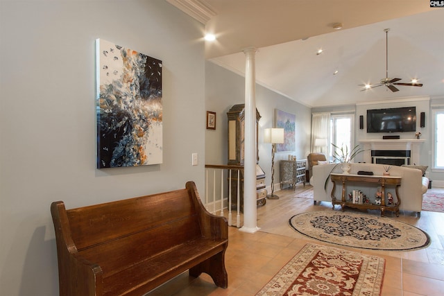 tiled living room with decorative columns, ornamental molding, lofted ceiling, and ceiling fan