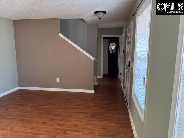 entrance foyer featuring dark hardwood / wood-style flooring and a textured ceiling